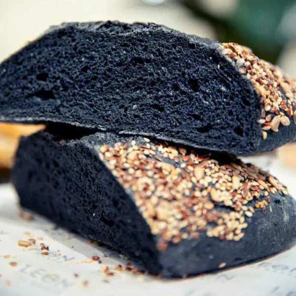 Pan negro con semillas cortado en rebanadas, mostrando su miga oscura