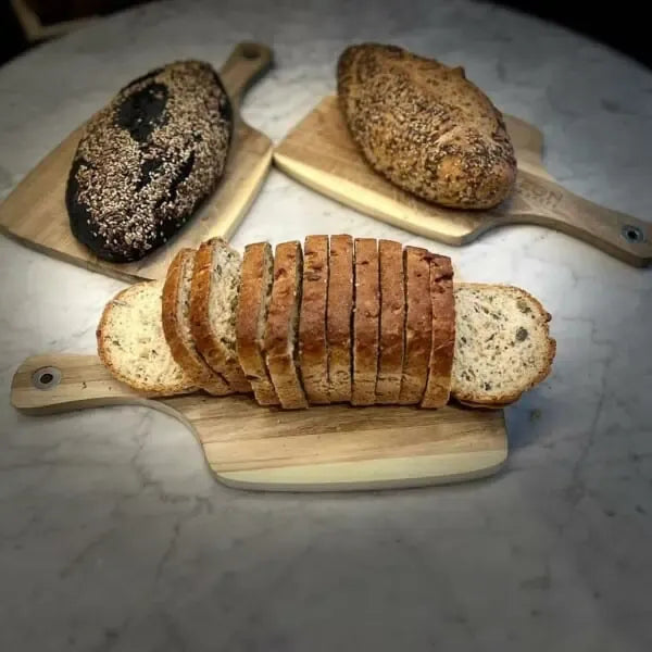 Pan artesanal rebanado colocado sobre una tabla de madera